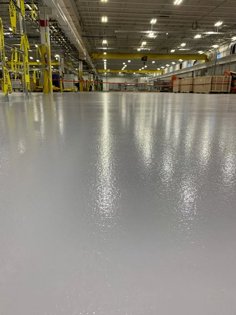 Glossy light-gray solid epoxy floor in an industrial warehouse