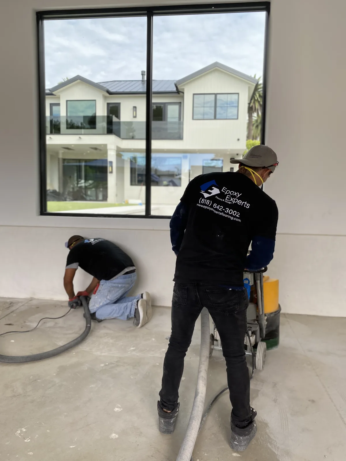 Epoxy Experts crew grinding a floor and edges with a machine