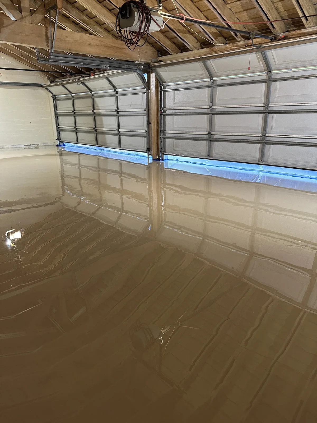 Beige solid-color epoxy floor in a two-car garage