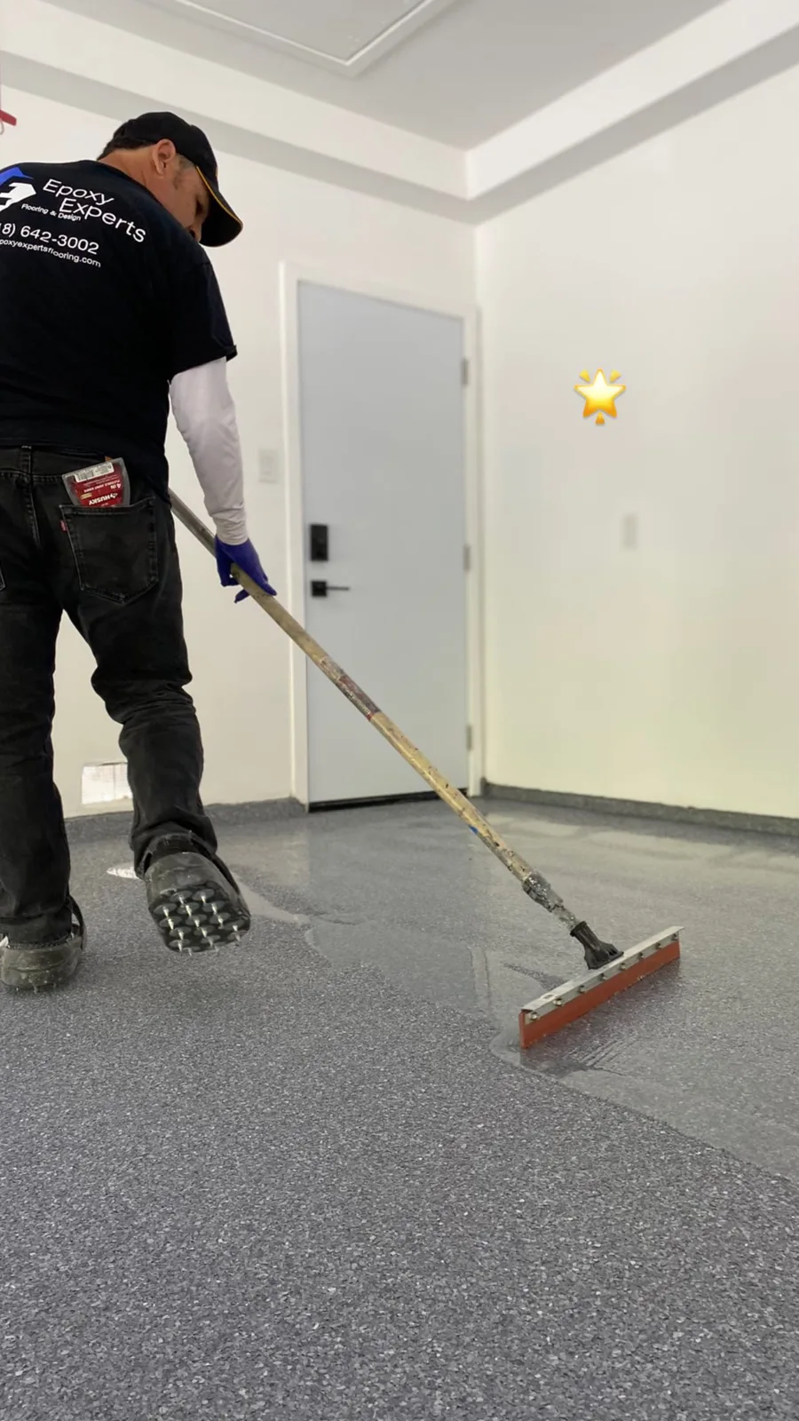 Epoxy Experts crew spreading the clear top coat with a squeegee